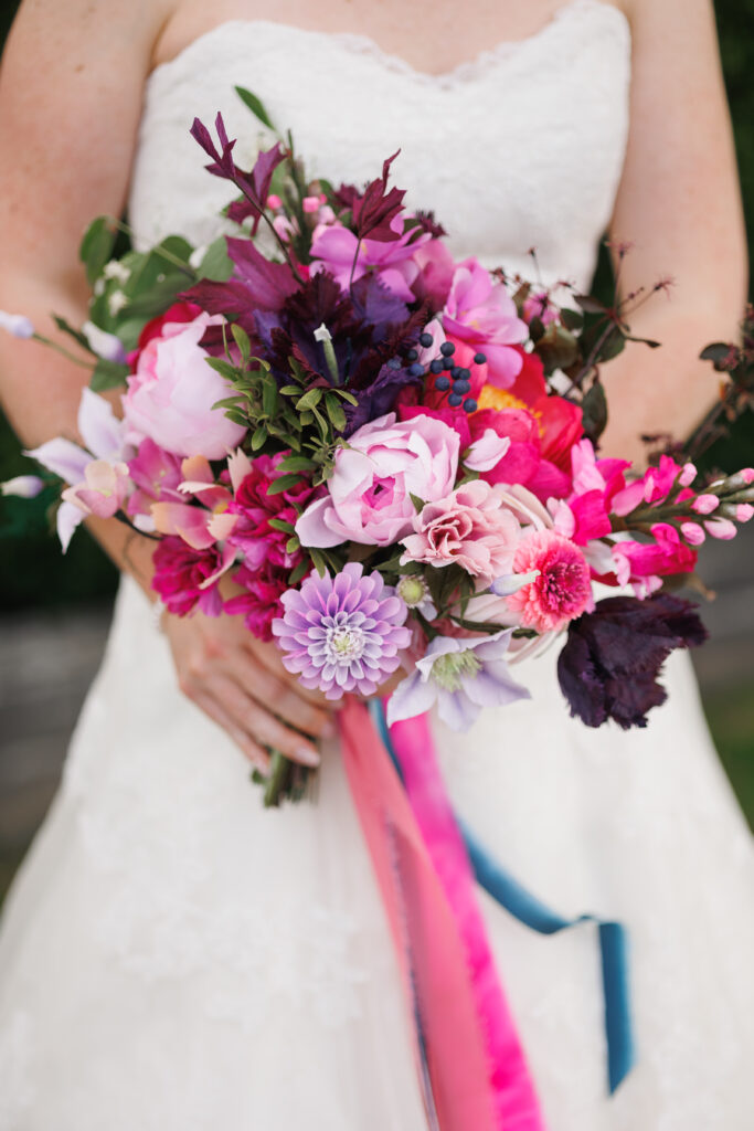 a closeup of a bride holding a bouquet of paper flowers